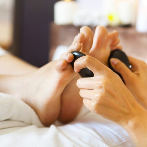 Massage of female foot in spa salon. Healthy lifestyle and relaxation concept. Close up